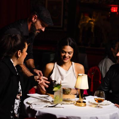 Guests seated at a table while being served drinks.