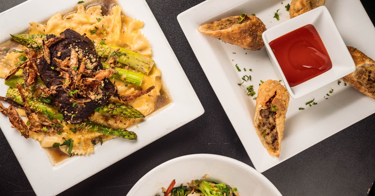 variety of dishes on table cheeseburger eggrolls with spicy ketchup, short rib with mac & cheese