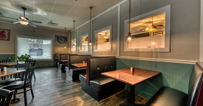 Interior of cozy dining area with upholstered booths along the wall