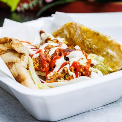 Lamb gyro with lettuce, tomatoes, onions, white sauce and hot sauce.