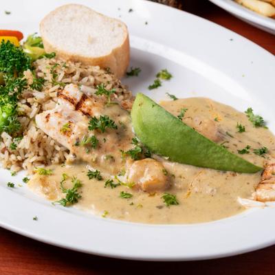 Grilled snapper and shrimp in creamy sauce, with rice and vegetables.