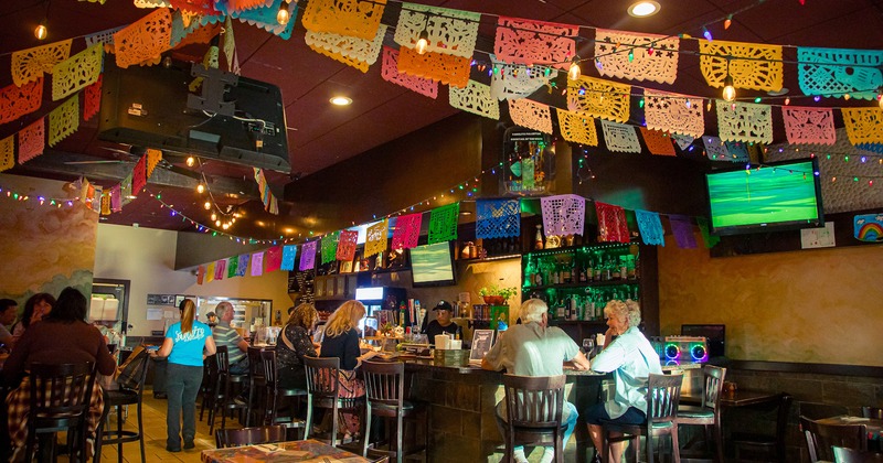 Interior space, guests at the bar counter chatting and enjoying their drinks
