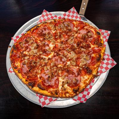 Pizza topped with peperoni, sausage, bacon, Canadian bacon and marinara sauce.