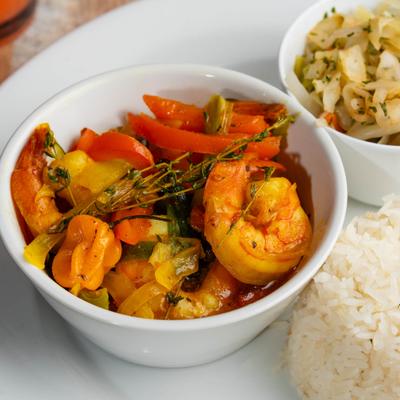 Curried shrimp with vegetables served with rice and stewed cabbage.