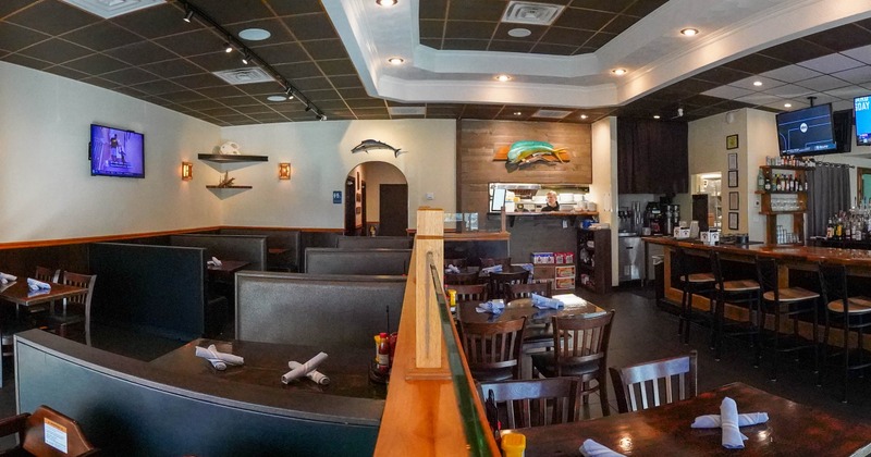 Restaurant interior with booth seating and a bar area