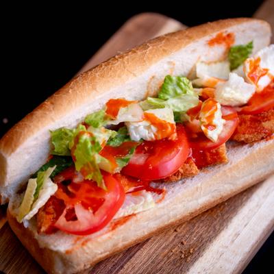 Buffalo chicken sandwich with lettuce and tomato.