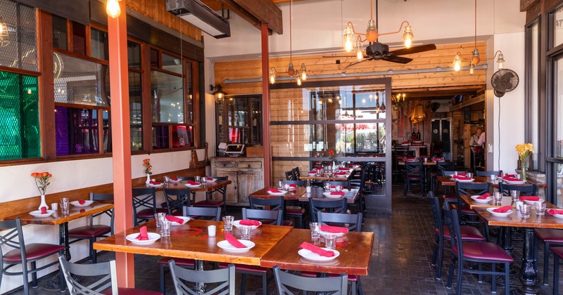 Interior, seating area, wooden top tables ready for guests, large sliding door