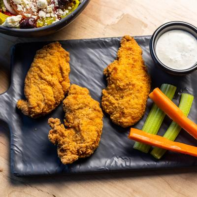 Chicken Tenders served with carrot and celery sticks and a dipping sauce.