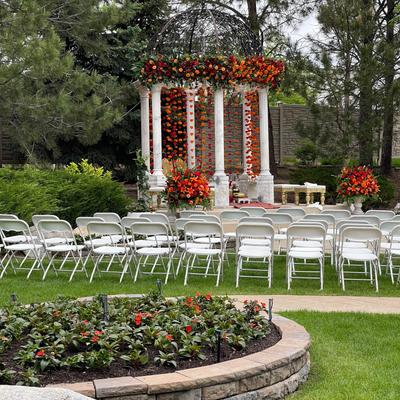 Garden space with wedding arches, garden flowers, floral decoration and seating area