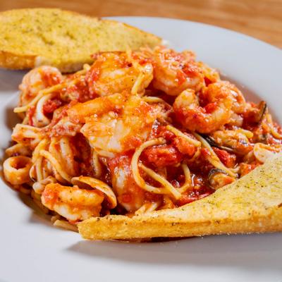 Spicy shrimp pasta served with toast on the side.