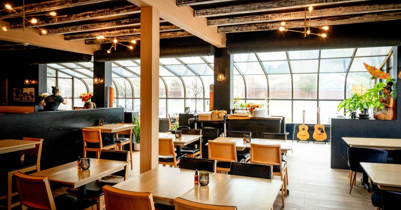Interior, seating area, tables for four, large arched glass canopy at the end of the room
