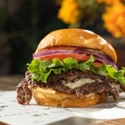 Double Smashburger with cheese, lettuce, onion and tomato.