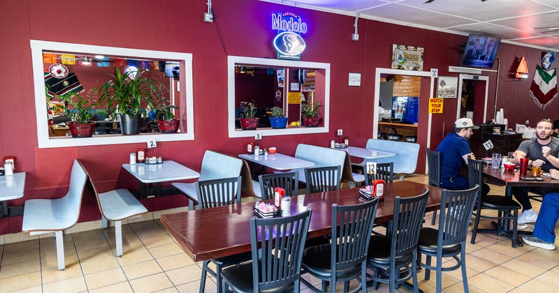 Casual restaurant with red walls, blue booths, and dark wood tables