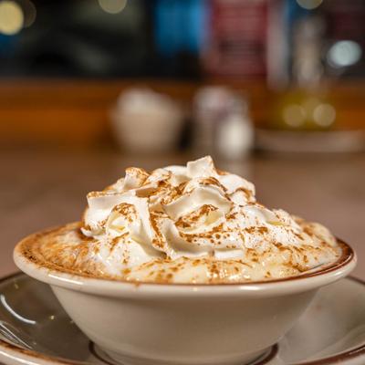 Rice pudding topped with whipped cream and sprinkled with cinnamon.