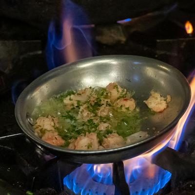 Food cooking in a wok on a flame from a gas stove