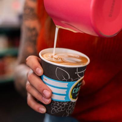 Barista making coffee with milk.