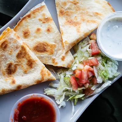 Cheese quesadilla with lettuce, tomatoes, and dips on the side.