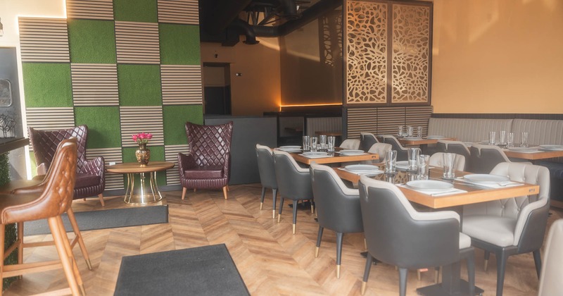 Restaurant interior with leather armchairs, decorative walls, and a dining area