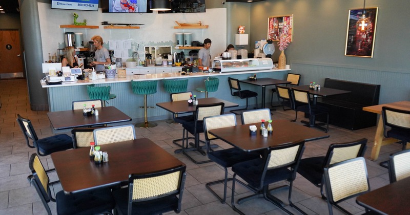 Inside, wooden tables, modern green stools
