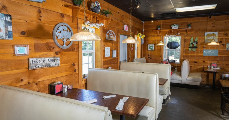 Interior, wooden walls, white booth seating, and warm pendant lighting