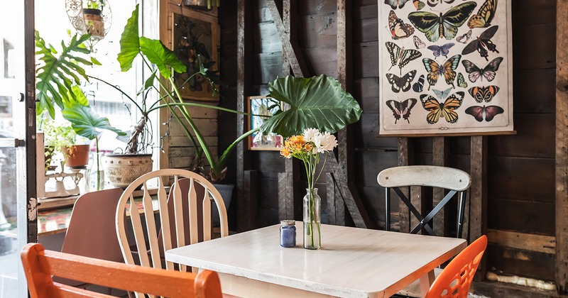 Interior, table for four guests in the corner with flower decoration