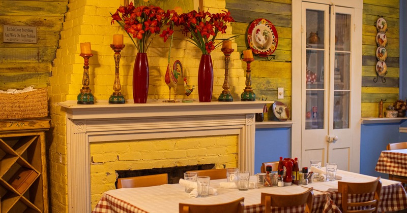 Interior, table with tableware and chairs next to the fireplace