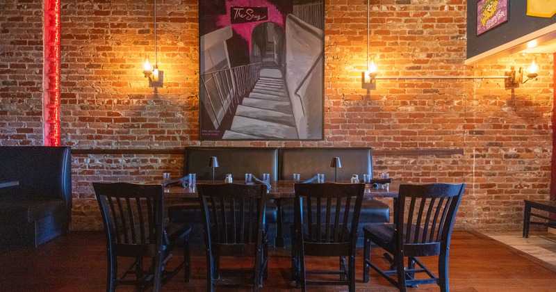 Diner table by brick wall, painting above