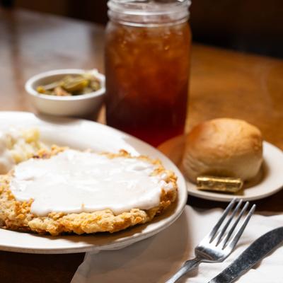 Chicken fried steak, bread roll, and sweet tea.