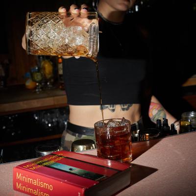 Bartender straining Little Italy cocktail.