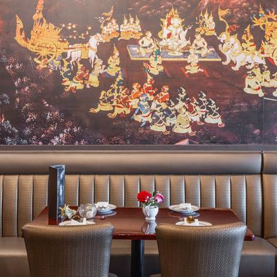 Interior, banquette tables, by a mural wall.