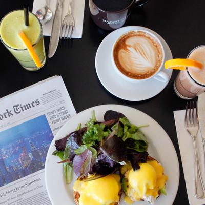 Eggs Benedict served with fresh-squeezed juices and a latte.