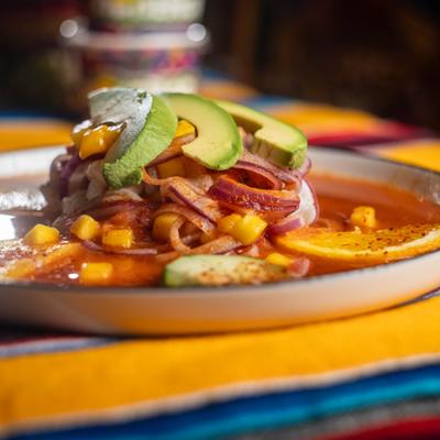 Aguachile Rojo with orange, cucamber and avocado slices.