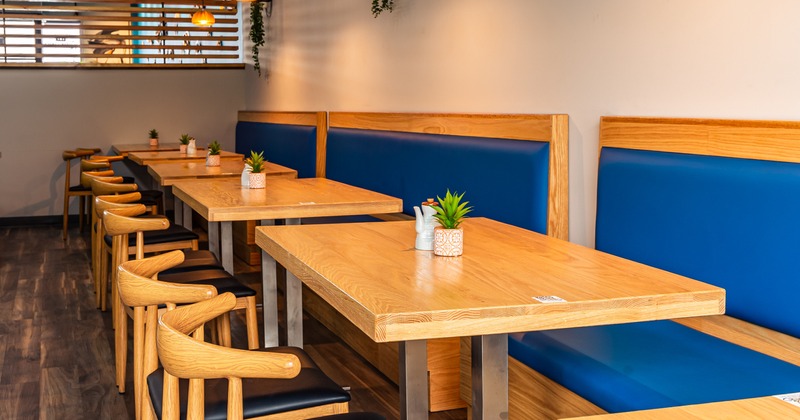 Interior, banquette seating by a wall with tables and chairs