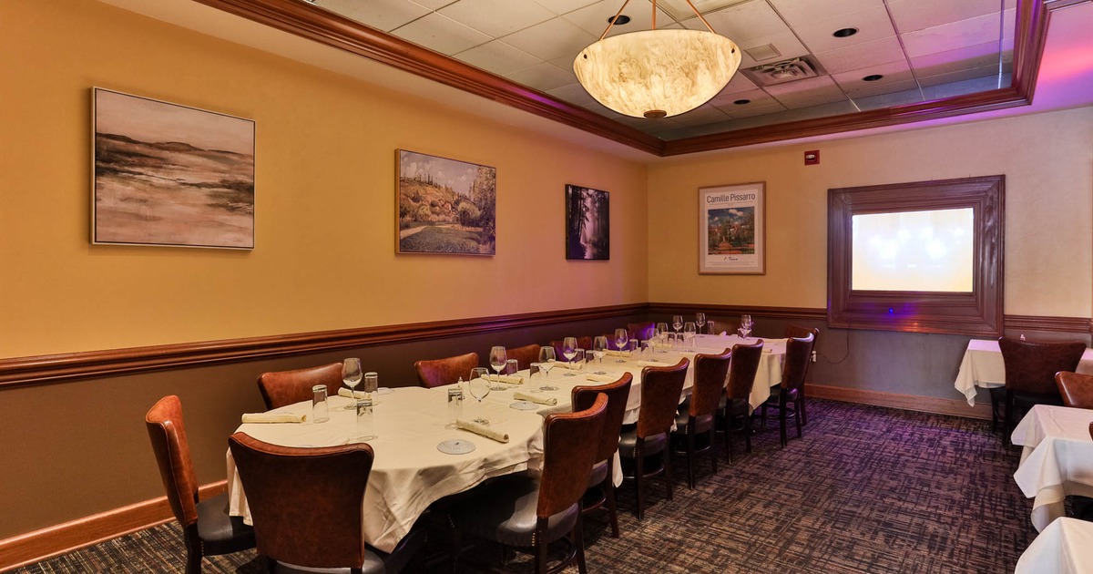 Interior, long table setup for sixteen, paintings on the wall, carpet flooring