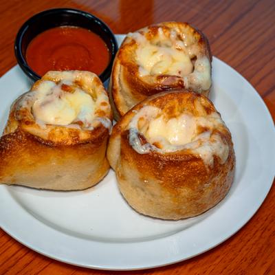 Pizza Pinwheels Meat Lover's served on a white plate with marinara.