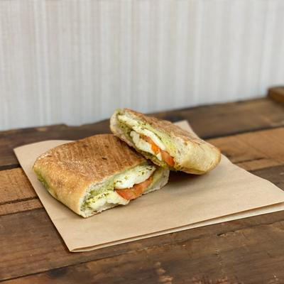 Pressed pannini sandwich with mozzarela, tomato and pesto.