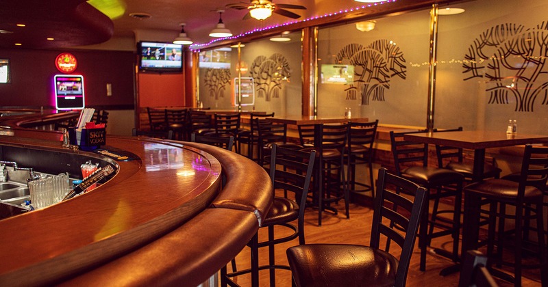 Interior, bar area and lined up tables for four