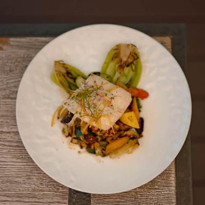 Seared white fish fillets paired with roasted Mediterranean-style vegetables.