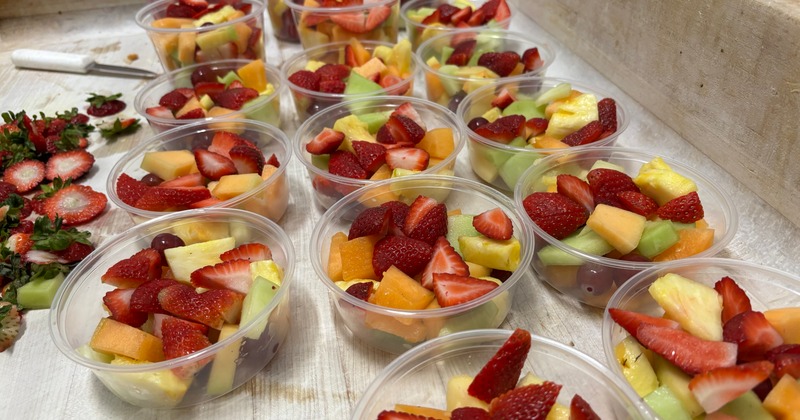 Fresh mixed fruit cups with strawberries, melon, pineapple, and grapes