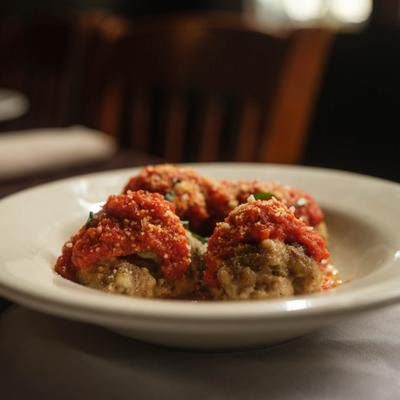 Homemade Meatballs topped with tomato sauce and grated cheese.
