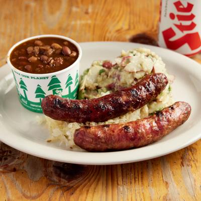 Two sausages served with sauerkraut and sweet and tangy baked beans.