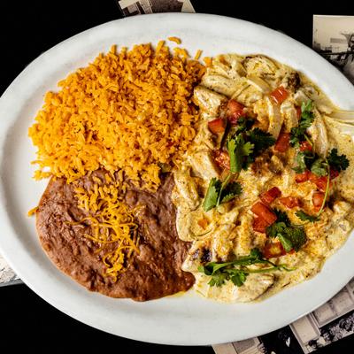 Grilled chicken chunks, smothered in sauce, with salsa, rice, and refried beans.