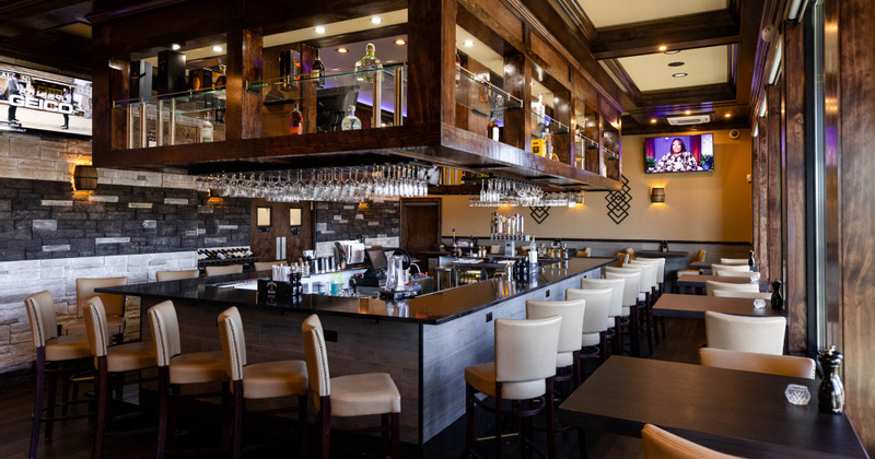 Interior, the bar with lined up chairs and individual tables on the right