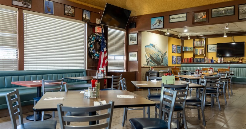 Interior of cozy and spacious dining area with dining tables ready for guests