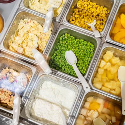 Metal containers filled with various toppings.