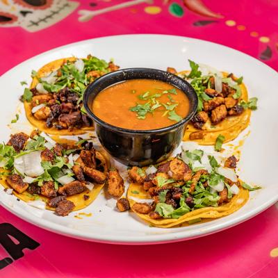 Plate of street tacos with dip.