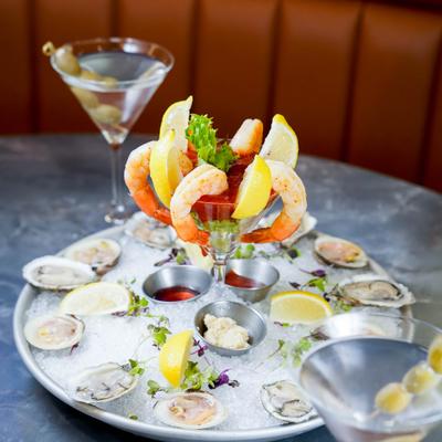 Shrimp cocktail and fresh oysters served on ice with olive martinis.