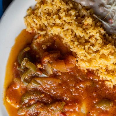 Fried eggs with chopped tomatoes, onions, jalapenos, rice and beans