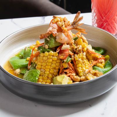 Avocado salad with corn, green beans, tomatoes, peanuts, shrimp, carrots, and lettuce.