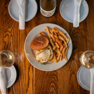 Burger with fries on the table.